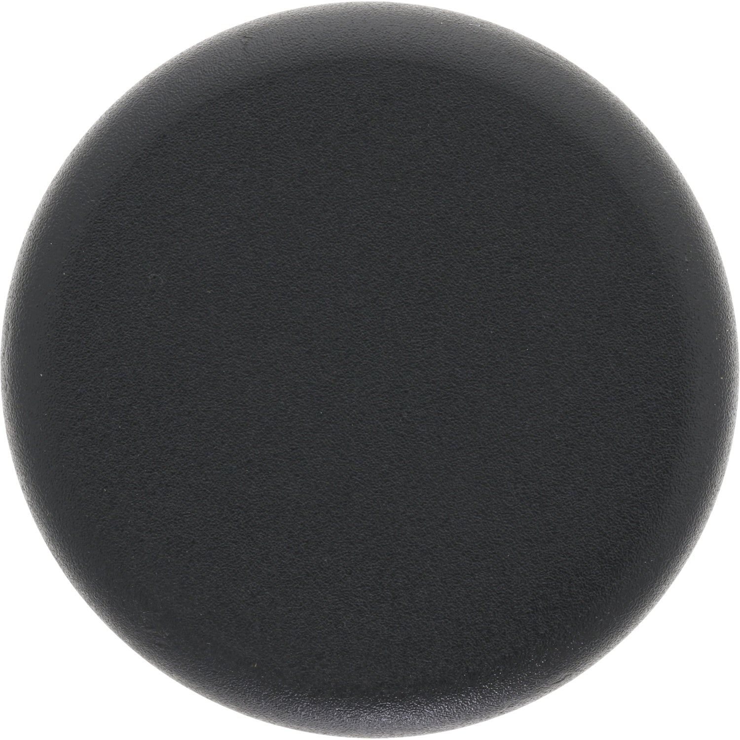 Low profile black plastic disk shaped plug on white background. 