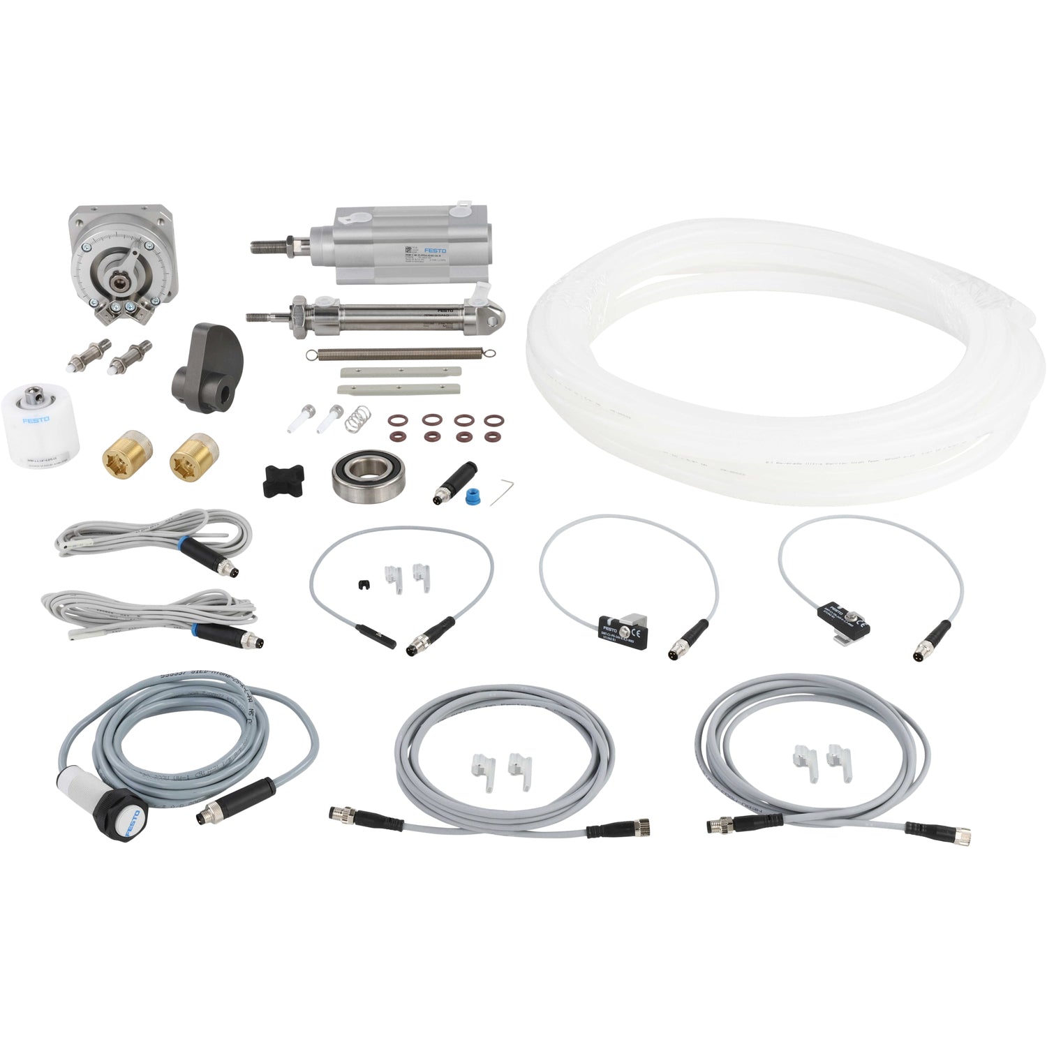 An assortment of parts that include pneumatic cylinders, sensor cables, o-rings, product tubing, springs, bearings and a rotary cam. Parts shown on a white background.